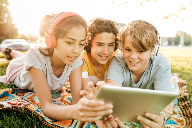 3 Kinder schauen in ein tablet